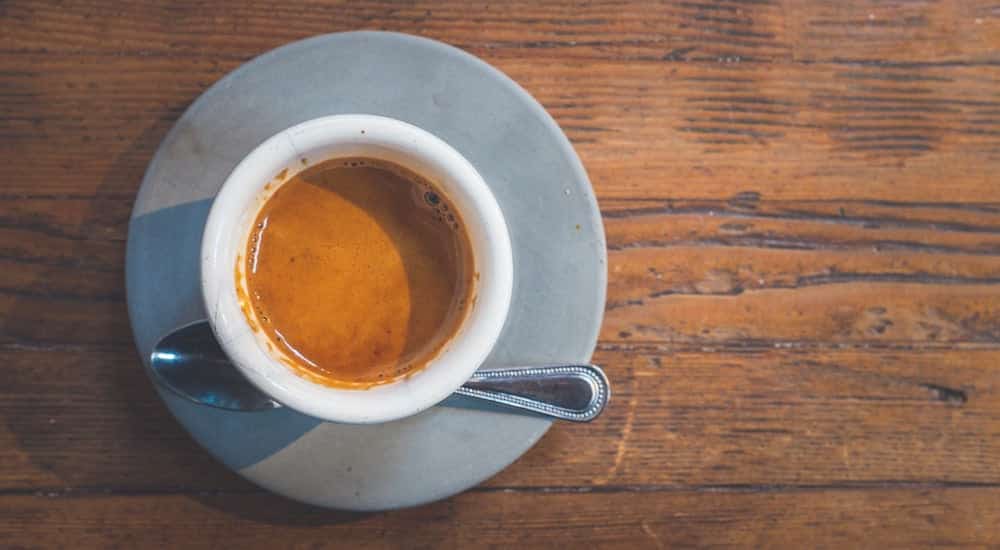 Frisch zubereiteter Espresso aus dem Espressokocher in weißer Tasse